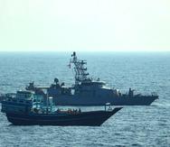 Foto suministrada por la Marina de Estados Unidos de barcos interceptando un bote en aguas internacionales en el Golfo de Omán.