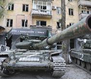 Tanks of Donetsk People's Republic militia stand next to a damaged apartment building in Mariupol, in territory under the government of the Donetsk People's Republic, eastern Ukraine, Wednesday, May 4, 2022. (AP Photo/Alexei Alexandrov)