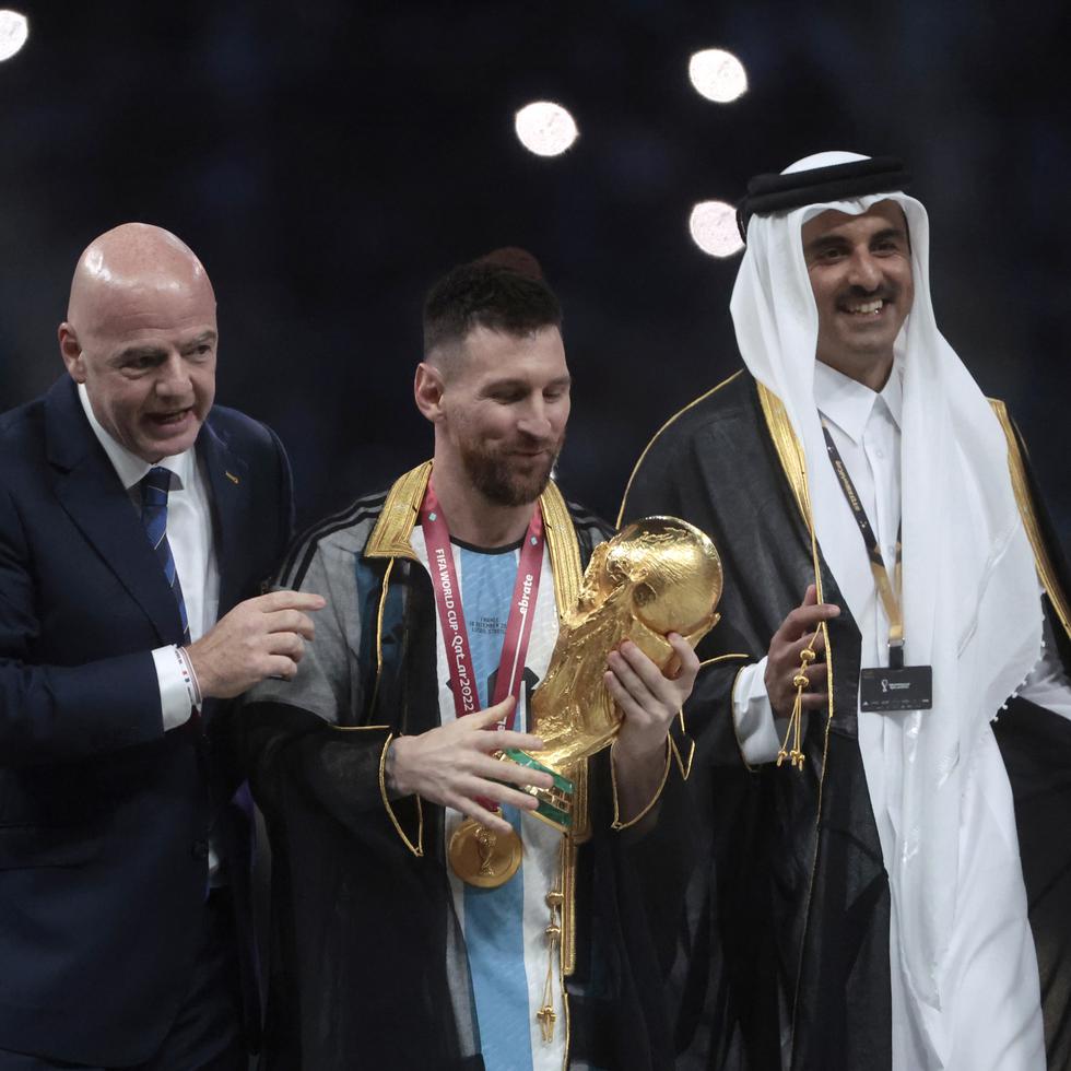Lionel Messi (centro) posa con el trofeo de la Copa del Mundo junto a el presidente de la FIFA Giovanni Vincenzo (izquierda) y el Emir del Estado de Catar, Tamim bin Hamad Al Thani.