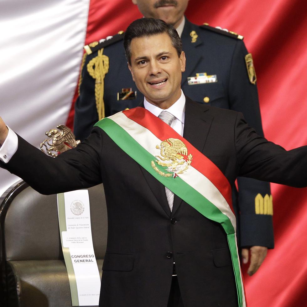 Enrique Pena Nieto, del Partido Revolucionario Institucional (PRI), viste la banda presidencial después de rendir juramento ante el Congreso como presidente de México, el 1 de diciembre de 2012, en la ciudad de México.