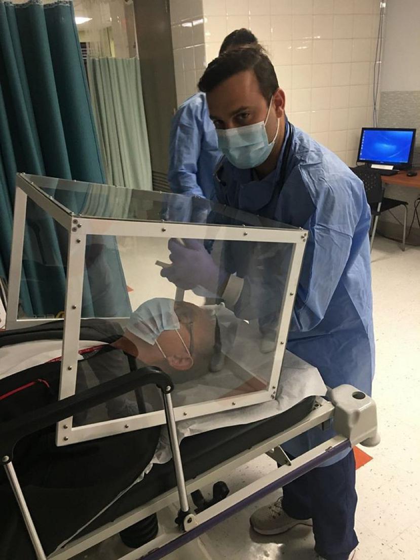 En la foto, personal médico en el Hospital Ryder de Humacao demuestra cómo utilizan la caja protectora que manufacturó MECCE Industrial. (Suministrada)