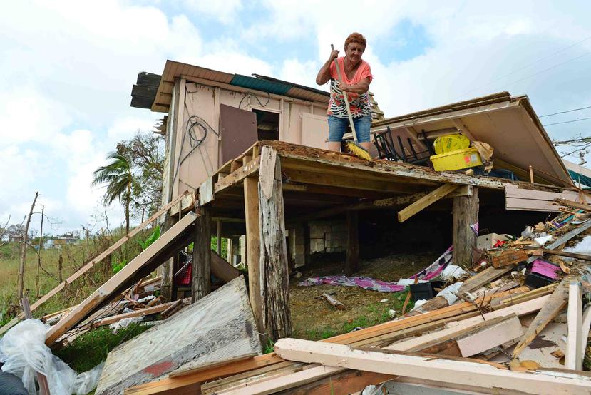 La corozaleña Virginia Rivera Ortiz limpia su casa. Se observan los escombros que dejó el huracán María a su paso por la isla.