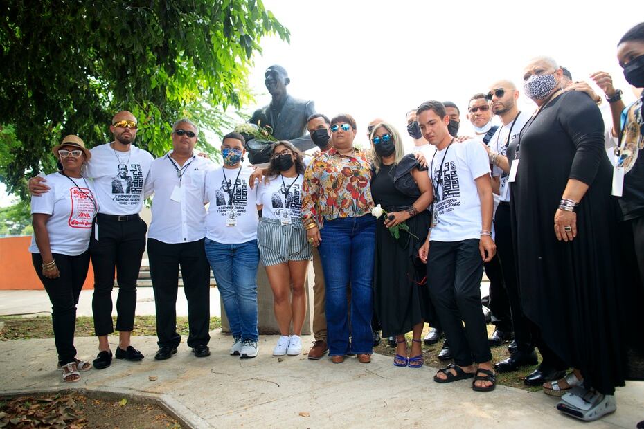 Familiares y amigos de Roberto Roena posan frente al busto del músico en la Plaza de los Salseros en Santurce.