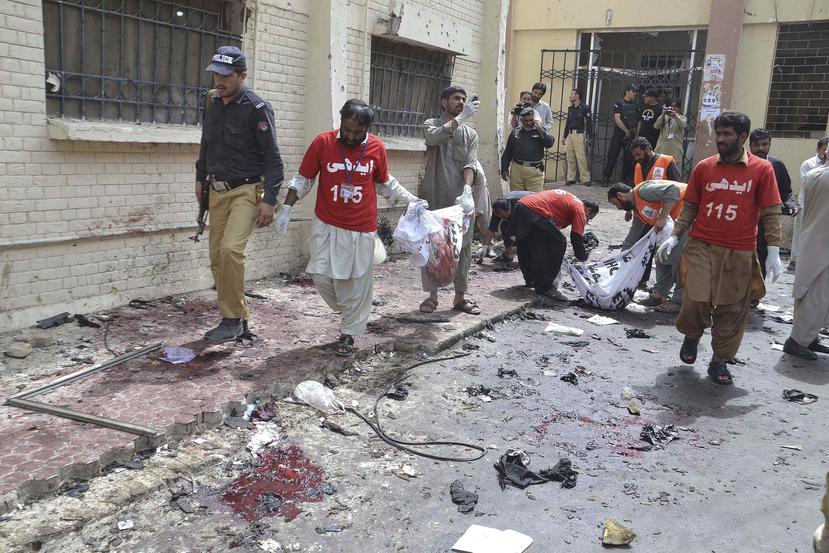 Trabajadores de los servicios de rescate recogen los cuerpos de las víctimas de un ataque con bomba en un hospital de Quetta, en Pakistán. (EFE / Fayyaz Ahmed)