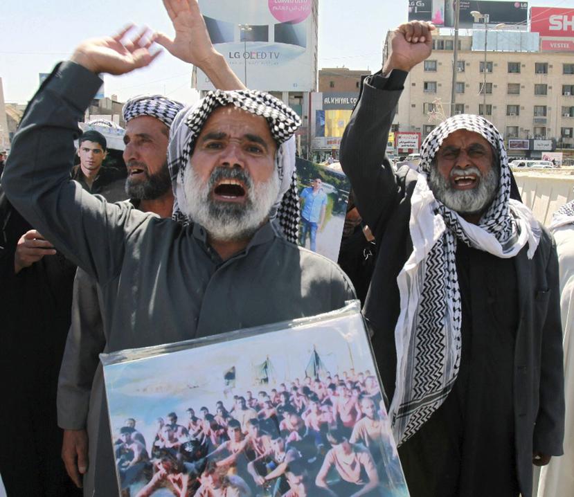 Varias personas sostienen fotos de víctimas del Estado Islámico. (EFE)